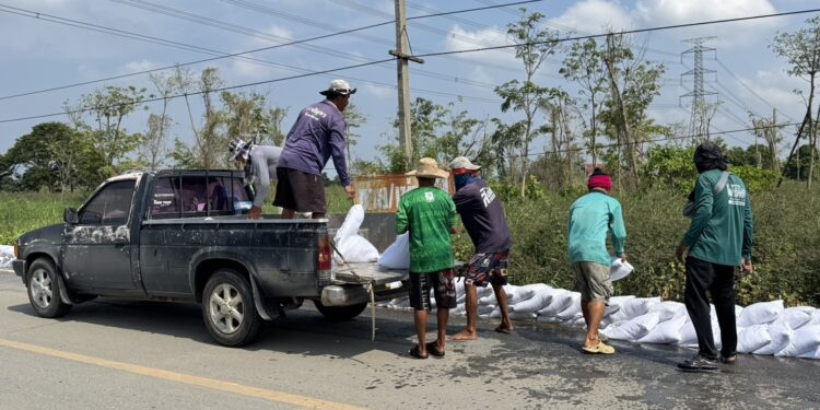 นครปฐม-ชาวบ้านนับร้อยคนช่วยกันกรอกกระสอบทรายหลังระดับน้ำท่าจีนสูงขึ้นต่อเนื่อง